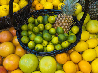 A variety of citrus fruits in the basket - limes, sweetie, lemons, oranges and others.