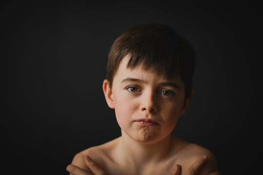 Close Up Of Young Boy With Serious Look On His Face.