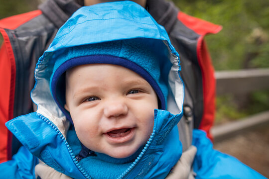 Cropped view of mother carrying her happy child in baby carrier