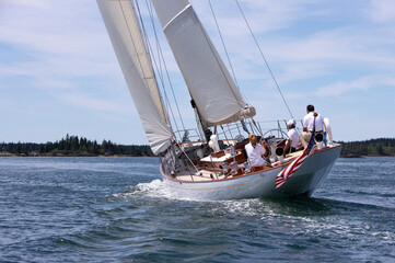 A classic wooden yacht sails through the Fox Island Thoroughfare off the coast of Maine.