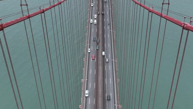 Traffic on The 25 April bridge (Ponte 25 de Abril) located in Lisbon, Portugal, crossing the Tagus river. Drone. 4k
