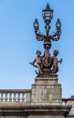 Fototapeta na wymiar An ornate lamp post with glass globes and cherubs located on the Alexander 3 bridge in Paris France.
