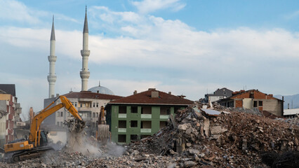 Fototapeta na wymiar Urban transformation, the process of redevelopment and revitalization of urban areas. Excavators in construction site demolishing old buildings in Golcuk Kocaeli Turkey. Selective focus included.
