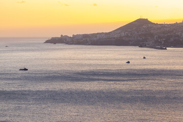 Great drone shot over the sea on a beautiful spring sunset with some boats in the foreground.