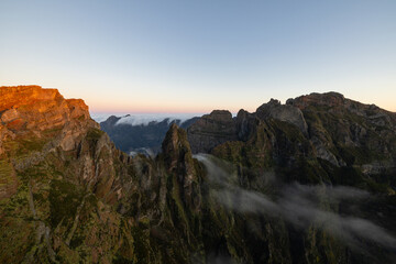 Fototapeta na wymiar Great sunrise on the Pico do Arieiro in Madeira with epic fog wrapping around the Ninho da Manta.