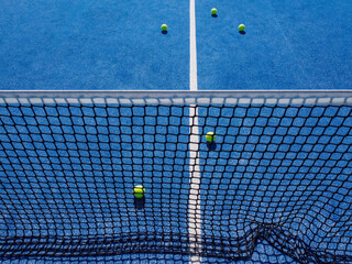 selective focus, view of the net of a paddle tennis court and several balls. Racket sports concept