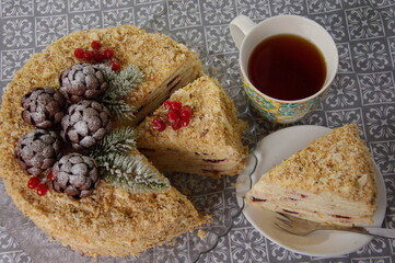 Napoleon cake decorated with christmas motifs and a cup of tea. 