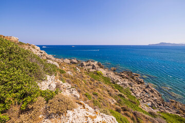 Fototapeta na wymiar Beautiful landscape view of island on dark blue sea water merging with cloudless sky on background. Rhodes. Greece. 