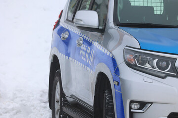 Radiowóz policji polskiej w górach na śniegu i we mgle.  Policja zimą.   