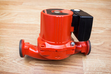 Red circulation pump for heating system lies on the floor