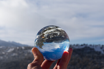 Reflection in a crystal ball of a mountain landscape with snow on a sunny day and blue sky. winter...