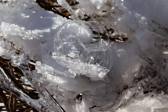 Macro photo of soap bubble on snow. Snow reflections. Winter landscape. Ice and snow.