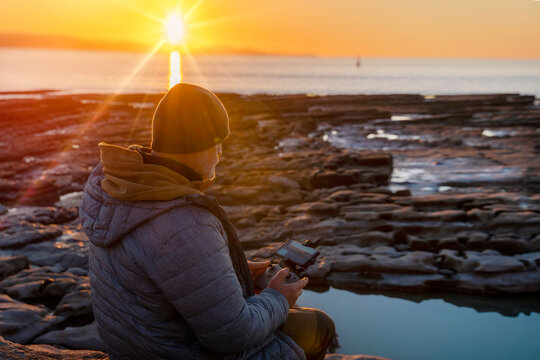 Bearded man using a drone with remote controller  making photos and videos,  having fun with new  technology trends