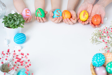 Colorful Easter eggs in hands with text. Holiday flat lay with copy space