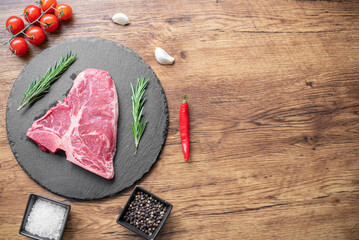 raw steak on a cutting board with herbs. Wooden background .with copy space for your text	