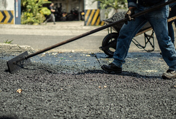 workers fixing potholes on the road