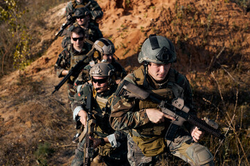 Group of military people during the operation against enemy, soldiers team in action, going to the...