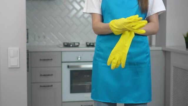 Housekeeping concept, Housemaid is wearing gloves and apron to prepare cleaning house. Professional maid woman wearing rubber gloves before cleaning, cleaning service company.