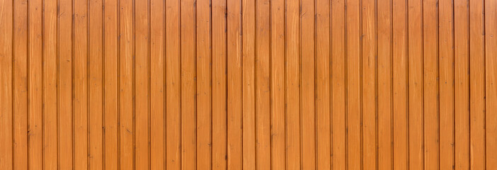 Honigfarben lasierte Panorama Holzwand aus senkrechten Brettern, befestigt mit einer Reihe Nägeln