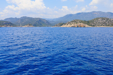 Naklejka premium View of the rocky shore from the sea. Mediterranean Sea in Turkey. Popular tourist places. Background