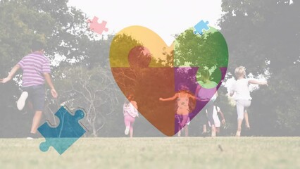 Animation of puzzle and heart over diverse schoolchildren running - Powered by Adobe