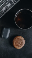 Morning coffee and cookies by the computer keyboard and headphones
