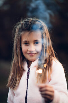 Two beautiful girls have fun with the sparks of a flare.