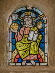 stained glass in a church wall depicting Jesus on the throne