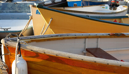 Colorful row boats are tied up in a marina.