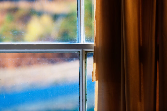 A window with torn curtains.