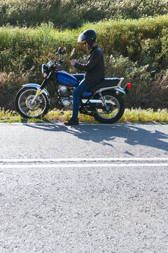 young man looking at the route to follow on his motorcycle with the mo
