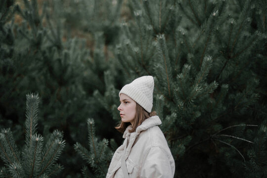 woman standing amidst pine trees at forest