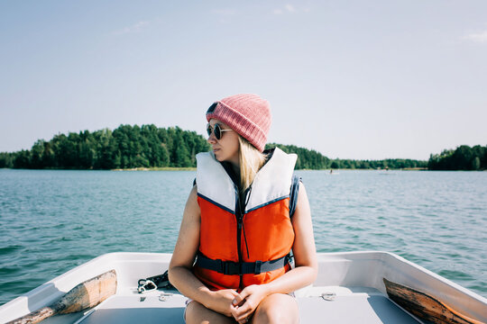 woman sitting peacefully on a rowing boat in summer on a lake