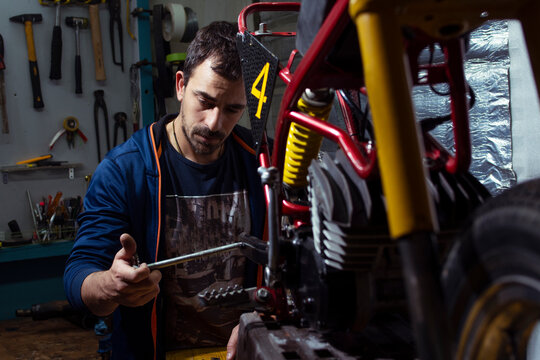 Engineer repairing motorcycle at auto repair shop