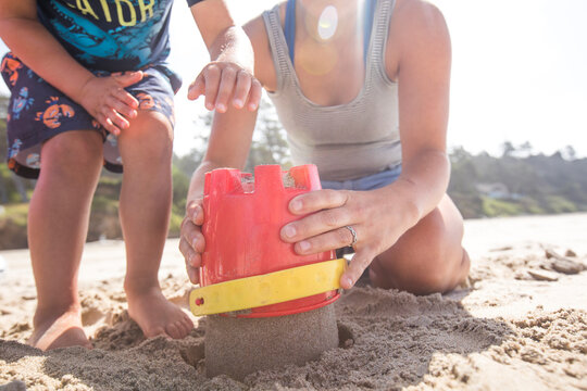 Low angle of mother and son building sand castle.