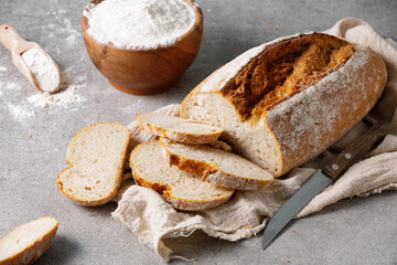 A loaf of sourdough wheat bread sliced on a towel