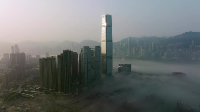 wide angle slow tracking right aerial shot of fog covered West Kowloon high-rise buildings, Hong Kong Island