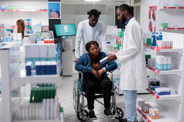 African american woman with disability shopping in drugstore, pharmacist recommending medicaments....