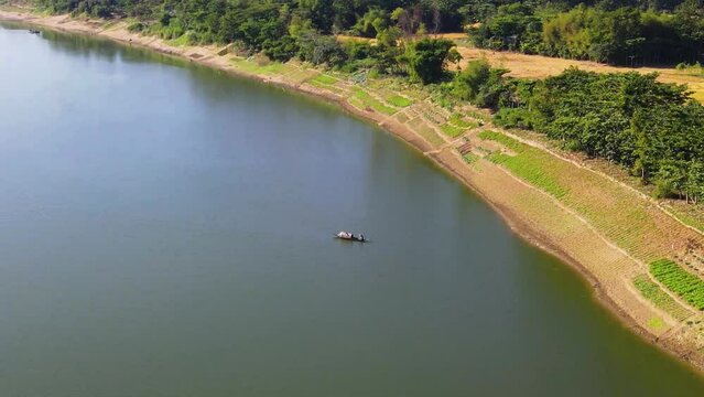 Wooden fisherman boat in vast river of Surma, Bangladesh. Aerial fly above view
