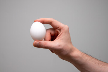 Fototapeta na wymiar close up of a person's hand holding white egg