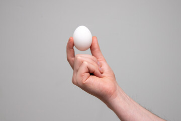Fototapeta na wymiar close up of a person's hand holding white egg
