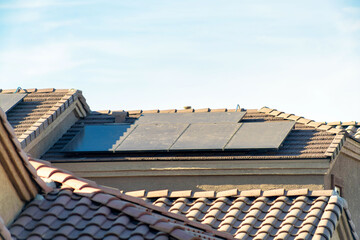 Solar pannels or photovoltaic generators on suburban rooftop in late afternoon sun in neighborhood...
