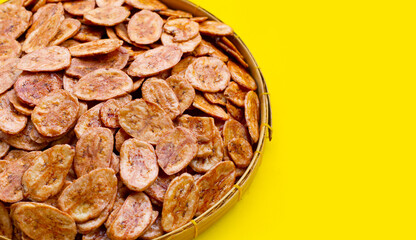 Banana chips on yellow background.