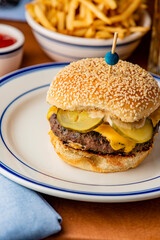 Hamburger. Bacon Cheeseburger. Classic traditional American bar, restaurant entree. Beef hamburger with Swiss and cheddar cheeses served with lettuce, tomato, onion and hand cut french fries. 