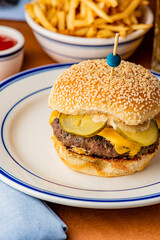 Hamburger. Bacon Cheeseburger. Classic traditional American bar, restaurant entree. Beef hamburger with Swiss and cheddar cheeses served with lettuce, tomato, onion and hand cut french fries. 