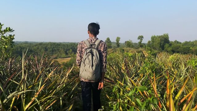 Young man walking in beautiful hilly landscape during trekking. Tracking shot