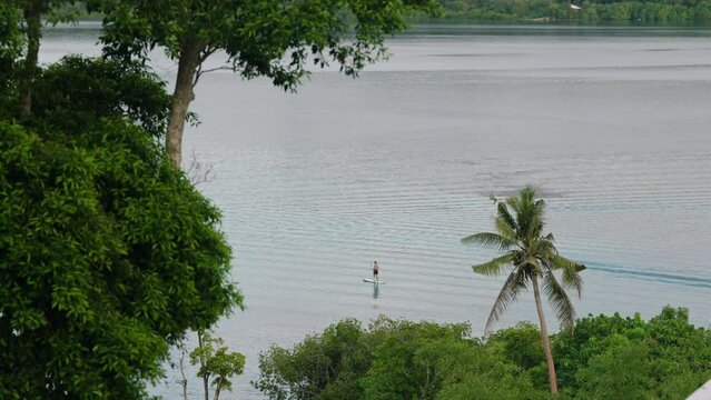 Tropical Seascape With Person Paddle Boarding In Moso Island, Coast of Efate, Vanuatu, Shefa Province. Wide Shot