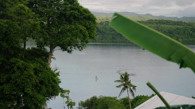 Tranquil Island With Man Paddle Boarding At Sunset In Moso, Off-Coast Efate In Vanuatu, Shefa Province. Wide Shot