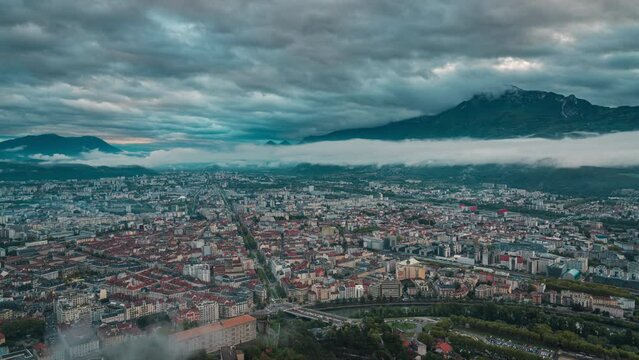 time lapse of Grenoble cityscape at sunset, aerial view of Grenoble city with clouds and mountain background