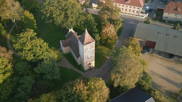 Village church bell tower shines at sunset. Smooth aerial view flight bird's eye view drone
Paretz Brandenburg Havelland Germany summer evening 2022. High Quality 4k Cinematic footage